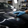 Applicator laying ceramic coating on a car hood
